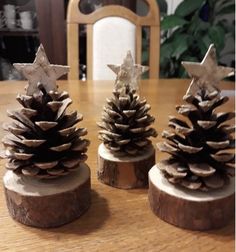 three small pine cones sitting on top of a wooden table