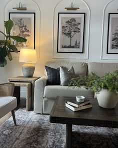 a living room filled with furniture next to two framed pictures on the wall above a coffee table