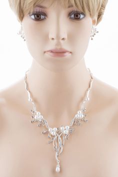 Elegant and exquisite, this silver-plated necklace and earring set features white faux pearls, clear crystal rhinestones in a stunning floral vine design. The floral design of this bridal set makes it an enchanting choice for your wedding. This set coordinates beautifully with your white or ivory dress. This lovely jewelry set sparkles with elegant beauty. This accessory would make a beautiful addition for weddings, proms, homecomings or any formal affair! The necklace has a lobster claw closure Silver Pearl Wedding Jewelry Sets, Formal Silver Pearl Bridal Sets, Formal Silver Rhinestone Necklace With Pearls, Elegant Silver Pearl Jewelry Sets, Silver Pearl Necklace With Rhinestones For Wedding, Silver Pearl Bridal Sets For Formal Occasions, Silver Pearl Rhinestone Necklace For Formal Occasions, Elegant Beaded Rhinestone Wedding Necklace, Elegant Silver Rhinestone And Pearl Necklace