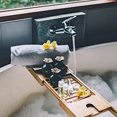 a bathtub filled with lots of soap and water next to a window sill