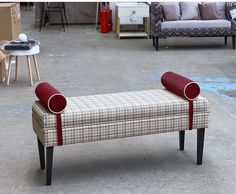 a bench that is sitting in the middle of a room with couches behind it