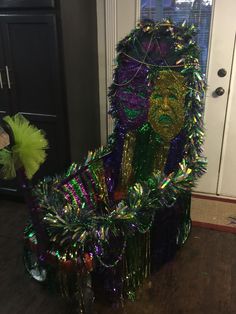 a green and purple costume sitting on top of a wooden floor next to a door