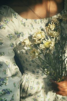 a woman in a white dress holding flowers