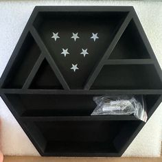 a black hexagonal shelf with white stars on it