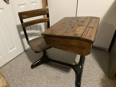 an old wooden desk and chair in a room