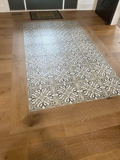 a white and black tile floor in a kitchen with wooden floors, cabinets and drawers