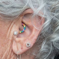 an older woman's ear has three piercings on it