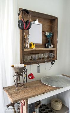 an old wooden shelf with various items on it and some tools hanging from the wall