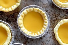 several pies are lined up on a baking sheet and ready to be baked in the oven