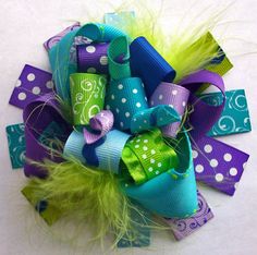 a green and purple hair bow with polka dots