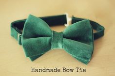 a green bow tie sitting on top of a wooden table with the words handmade bow tie