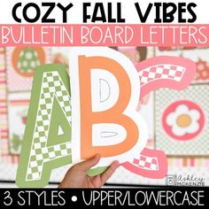 a hand holding up a paper cutout that says, cozy fall vibes bulletin board letters