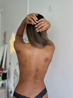 the back of a woman's body with her hands on her head and fingers above her head