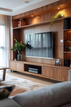 a living room filled with furniture and a flat screen tv on top of a wooden entertainment center