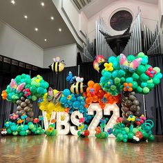 balloons are arranged in the shape of bees and honeybees on top of a stage