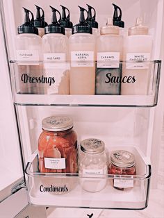 an open refrigerator filled with lots of different types of condiments and jars on the shelves