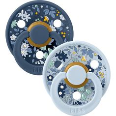 two blue and white pacifiers with floral designs on the sides, one has an orange ring