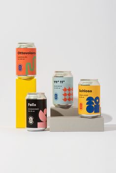 three cans of soda are sitting on top of each other in front of a white background