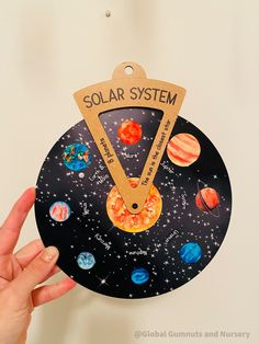 a hand holding up a solar system craft