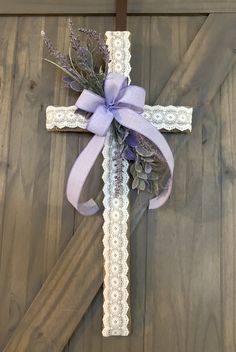 a cross decorated with lavender flowers and lace