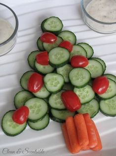 cucumbers, tomatoes and carrots arranged in the shape of a christmas tree