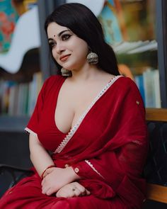 a woman in a red dress sitting on a bench