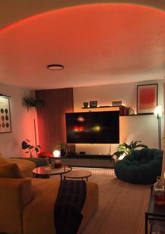 a living room filled with furniture and a flat screen tv mounted on the wall above it