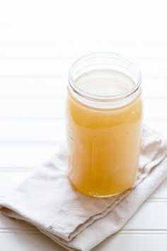 a glass jar filled with liquid sitting on top of a napkin