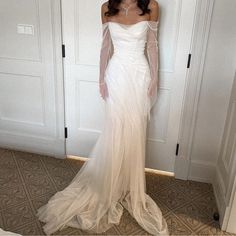 a woman in a white dress standing next to some closet doors