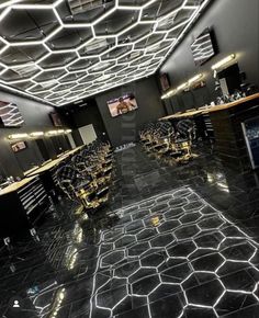 the interior of a barber shop with black marble flooring and gold accents on the walls