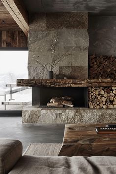 a living room filled with furniture and a fire place next to a wall covered in logs