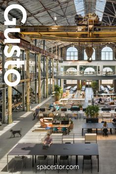 the interior of an industrial building with lots of tables and chairs