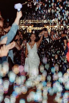 a bride and groom are surrounded by bubbles