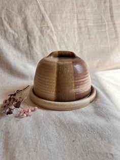 a wooden bowl sitting on top of a white sheet