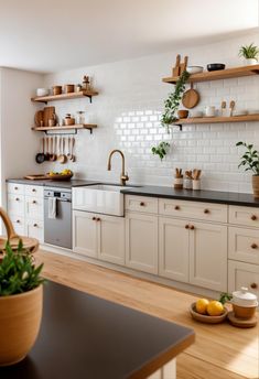 a kitchen with white cabinets and wooden shelves