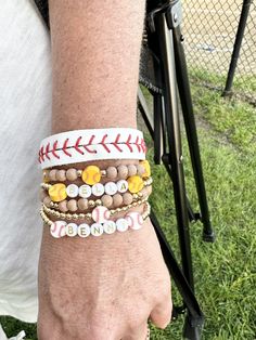 a close up of a person's arm wearing bracelets with baseball balls on them