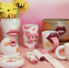 various vases and cups with lipstick painted on them