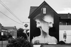 a black and white photo of a woman's face painted on the side of a building