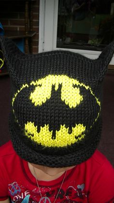 a young boy wearing a knitted batman hat