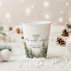 a paper cup with the words baby it's cold night on it next to christmas decorations