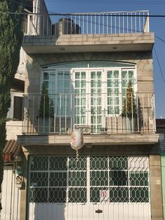 an apartment building with balconies on the second floor and balcony above it is shown