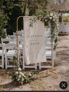 an outdoor wedding ceremony with white chairs and greenery on the aisle, which has a sign that says victoria and adam