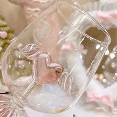 there is a glass with a pink horse on it and other decorations in the background