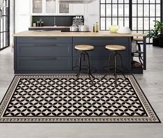 a kitchen with an area rug on the floor and two stools in front of it