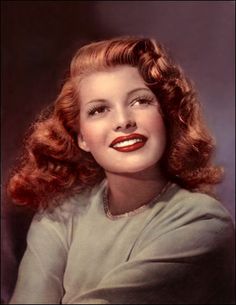 an old photo of a woman with long hair and red lipstick on her lips, wearing a green dress