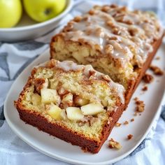 two slices of apple bread on a plate next to some apples and a bowl of fruit