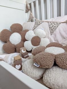 stuffed teddy bears in a white crib next to pillows