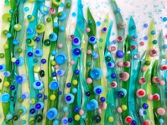 an abstract painting with many different colors and shapes on it's glass stems, as well as beads