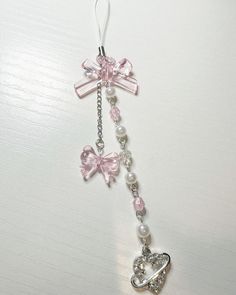 a key chain with a heart and bow hanging from it's side on a table