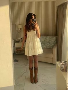 Non Country Cowboy Boot Outfit, Straw Hat And Dress Outfit, Sundress Cowgirl Boots, White Flowy Dress With Cowgirl Boots, Cute Stagecoach Outfits, Women’s Western Boots Outfits, Taylor Swift White Dress Cowboy Boots, Sundress Cowboy Boots Summer Outfits, White Sundress With Cowboy Boots